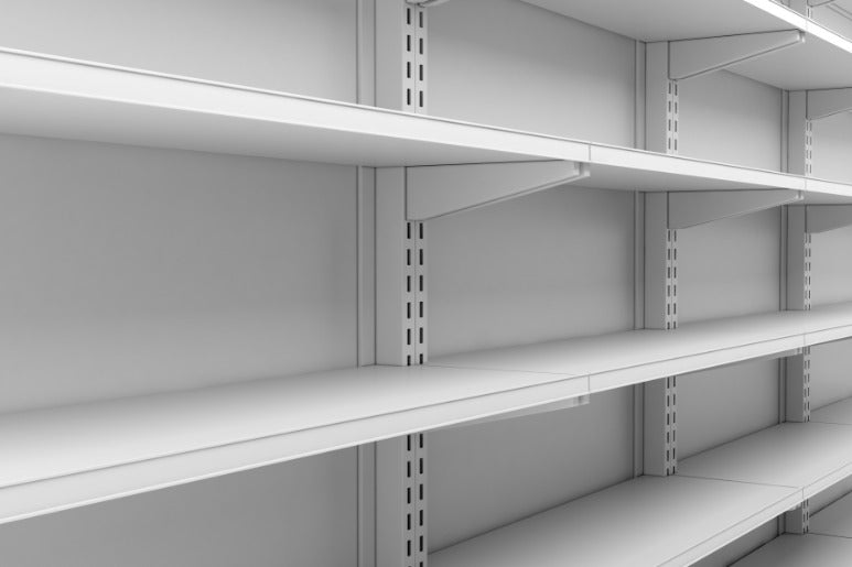 An aisle in a retail store with empty white shelving and newly installed brackets. The brackets are attached to slats.